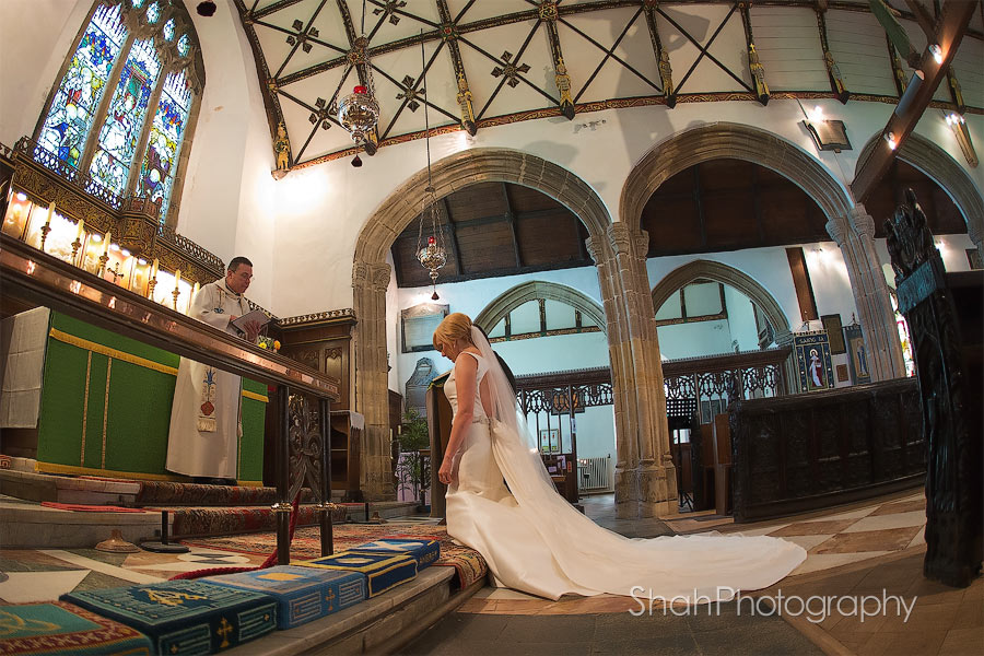 The bride and groom photographed kneeling at the alter during a prayer at St Ives Parish Church