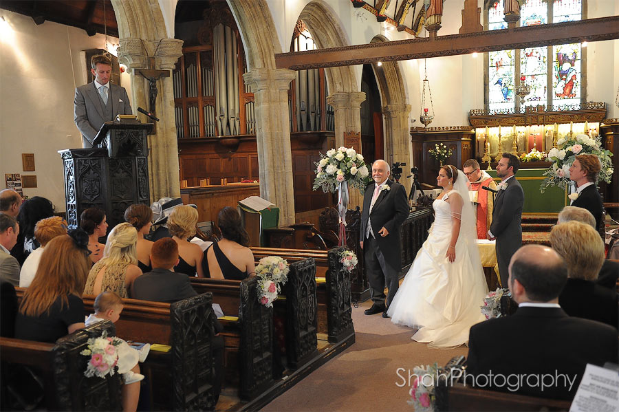 The bride and groom listen to a reading during their wedding ceremony