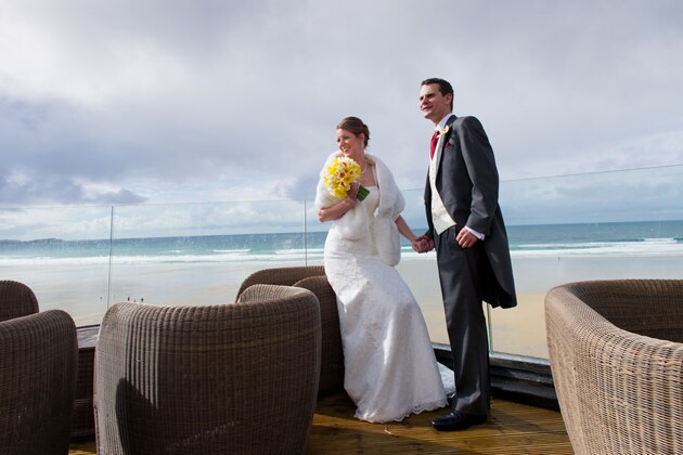 bride and groom with Watergate Bay beach backdrop