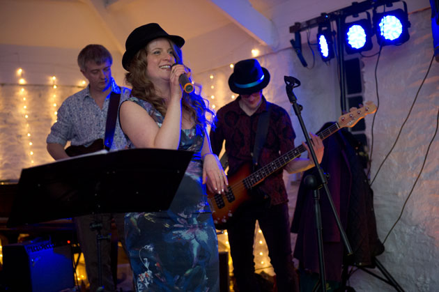 bride and groom with their band entertain their wedding guests