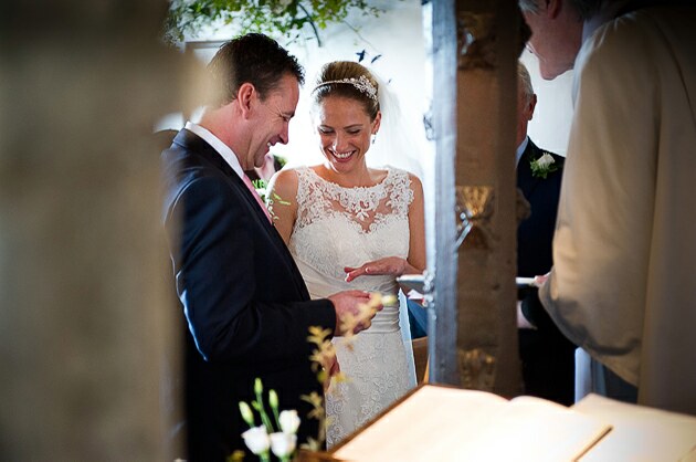 Wedding ceremony Porthilly Church Rock groom puts wedding ring on brides finger