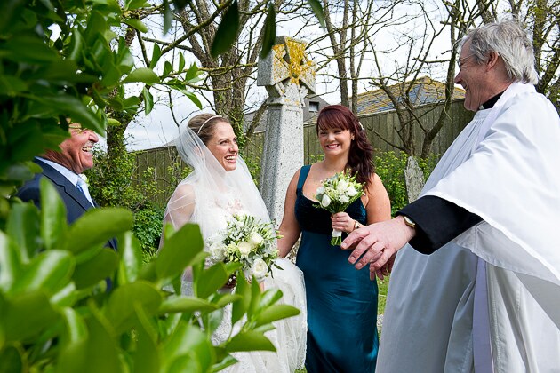 Wedding photograph of vicar welcoming the bride for her wedding at St Michael's church Porthilly Rock