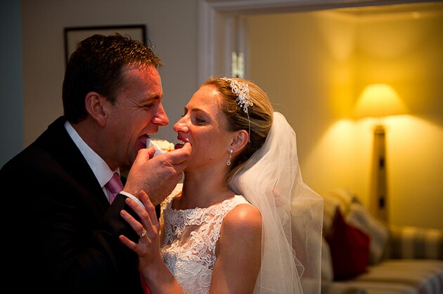 Relaxed wedding photography of bride and groom about to share wedding cake