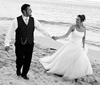 Nicky and gary the bride and groom photographed on Carbis bay beach after their wedding breakfast at Tregenna Castle, St Ives 