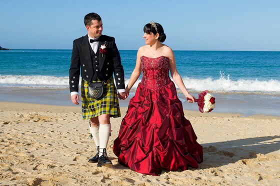 Bride and groom enjoy a stroll on Carbis Bay beach in glorious Cornish sunshine