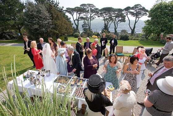 wedding guests enjoy the setting of Fowey Hall grounds