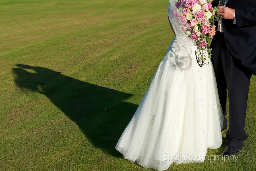 The photographer has featured the shadow of the bride and groom which include the wedding dress from the waist down and bouquet