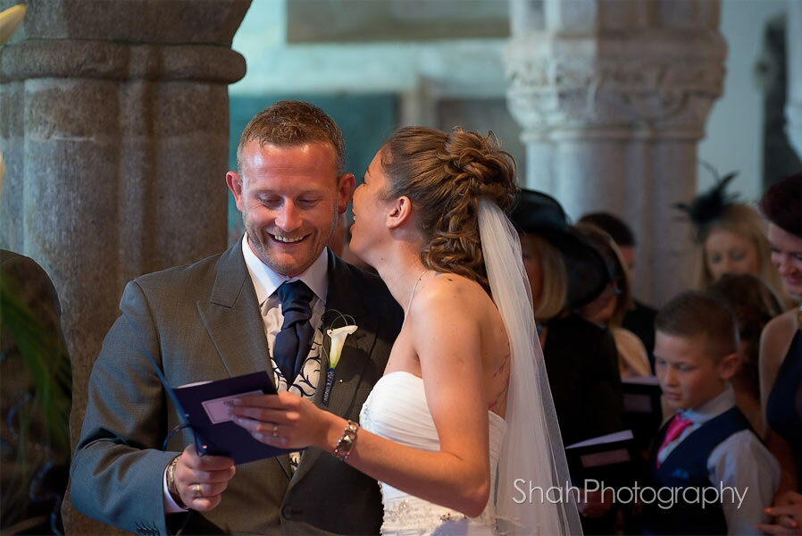 A whisper in the groom's ear from the bride during their church wedding ceremony. Lelant church near St Ives, Cornwall
