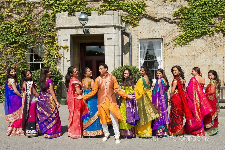 Colourful saris feature in this group of wedding guests with the groom in his equally colourful wedding outfit