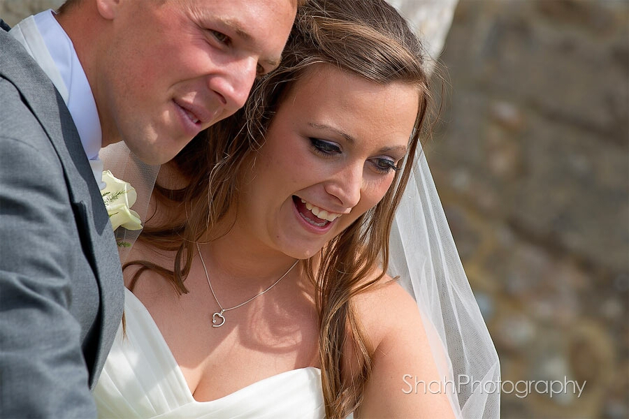 Natural expressions of the smiling, happy couple. A close up taken while the couple were chatting with one of the children after their wedding ceremony