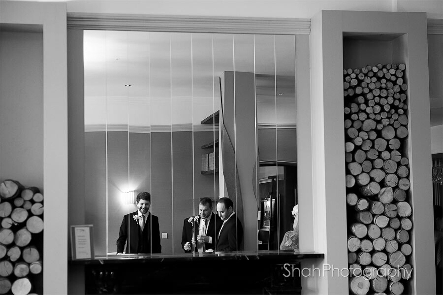 Black and white contemporary photo featuring the groom and ushers reflected in a mirror