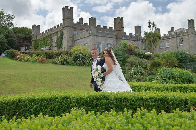 the bride and groom with backdrop of wedding venue Tregenna Castle