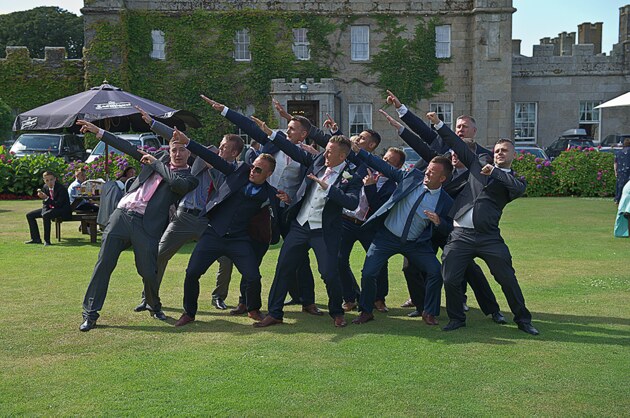 groom and groomsmen strike a pose infront of Tregenna Castle