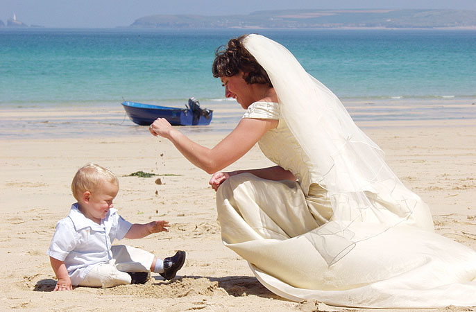 wedding photograph of bride and page boy taken on Carbis Bay beach near St Ives in Cornwall