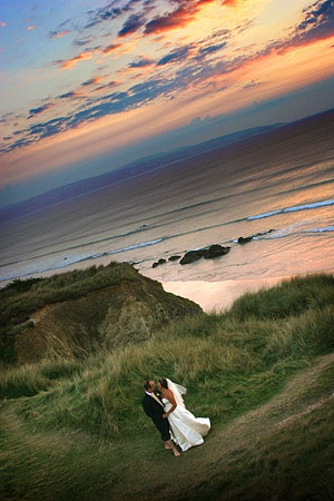 bride and groom photographed at Gwithian sand dunes with a spectacular Cornish sunset
