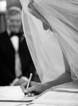 wedding photograph of bride signing the register